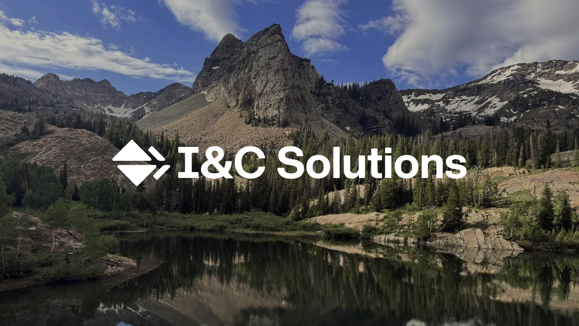 The I&C Solutions logo in white over a mountain lake