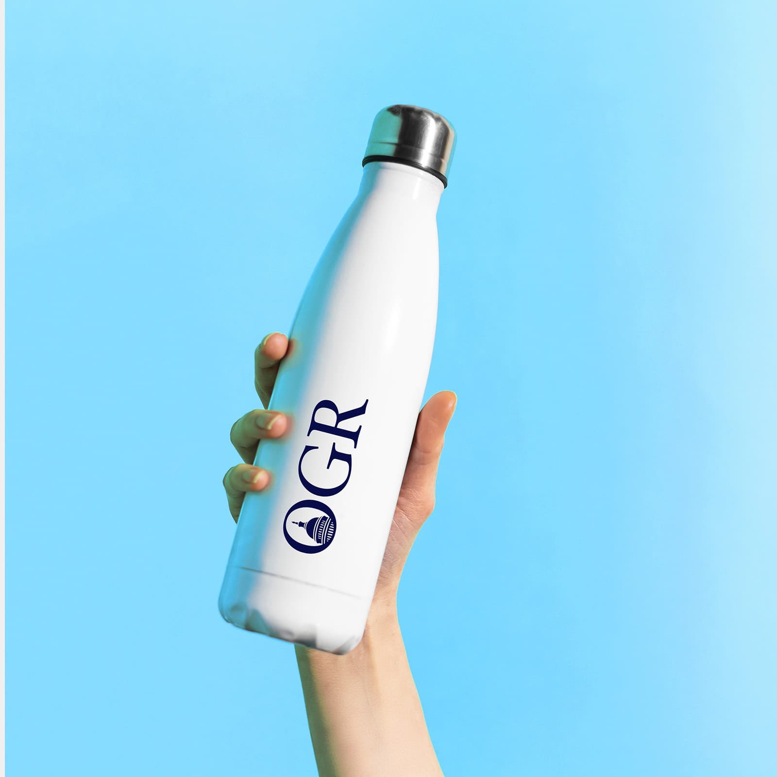 White water bottle with the OGR logo, held up against a blue sky